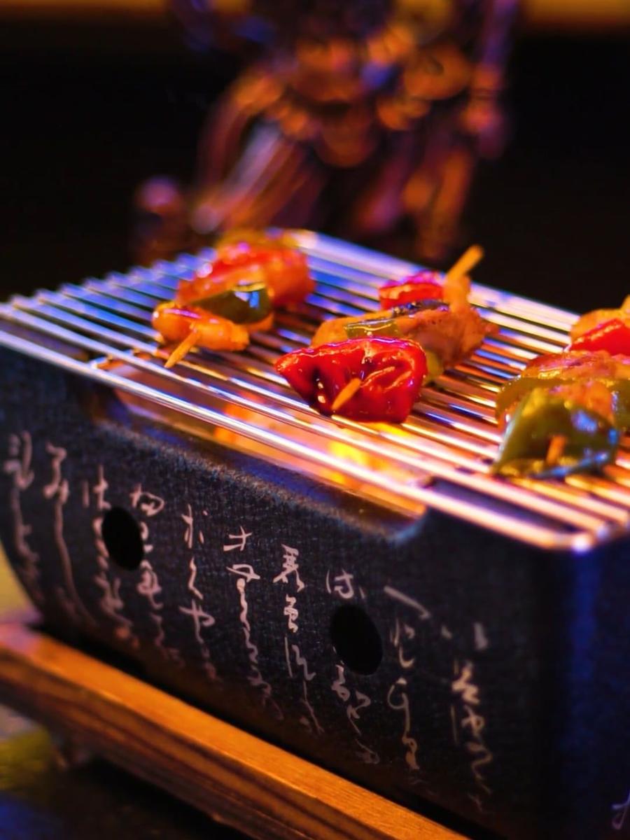 Skewers over a small charcoal grill