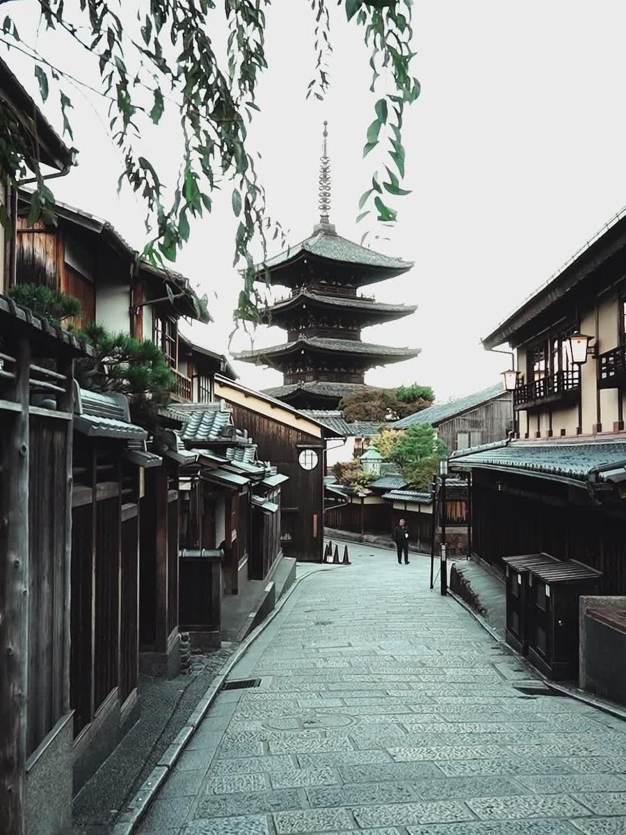 A quiet stone street in Kyoto leading to a pagoda