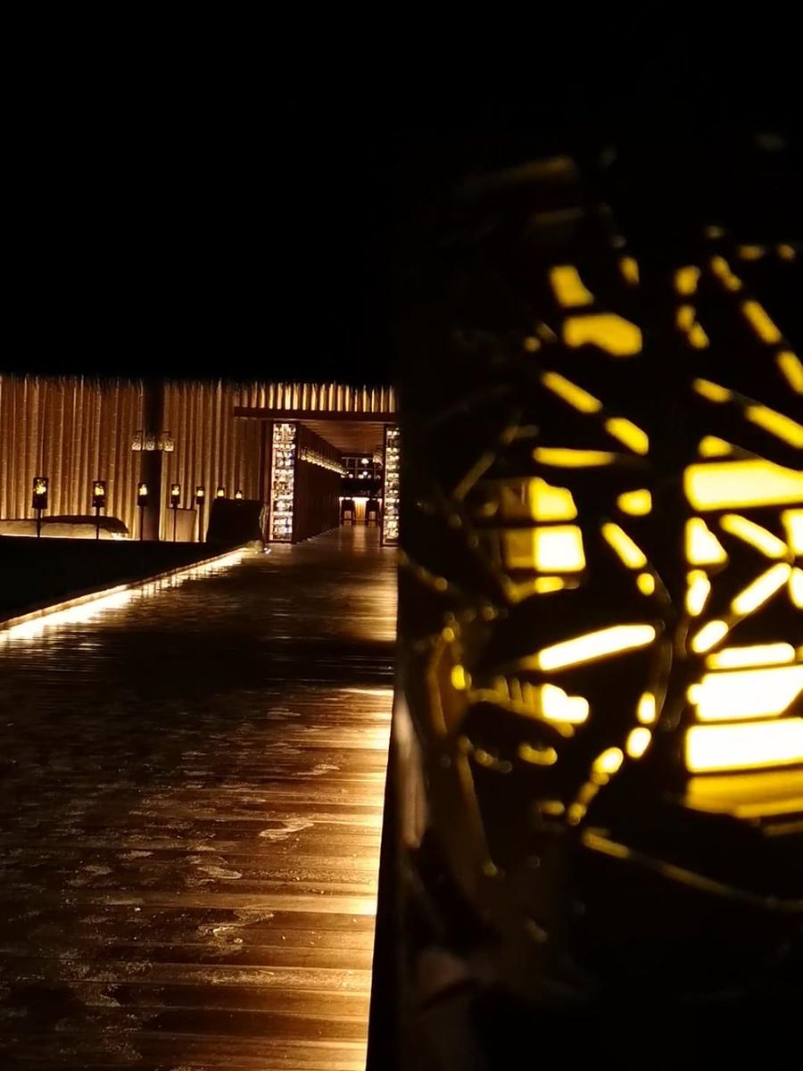 A lantern glowing beside a wet path at night